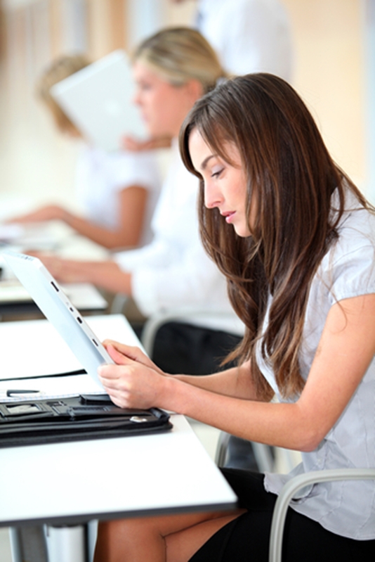 A young woman studies information on a tablet.